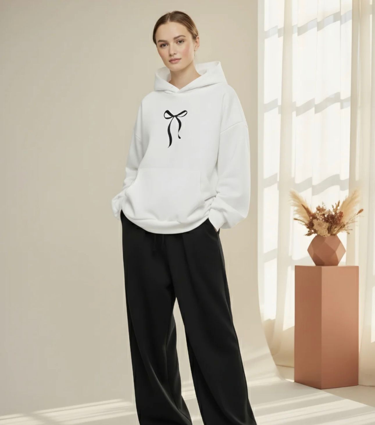 Women's casual hoodie featuring a minimalist black coquette bow graphic on the chest