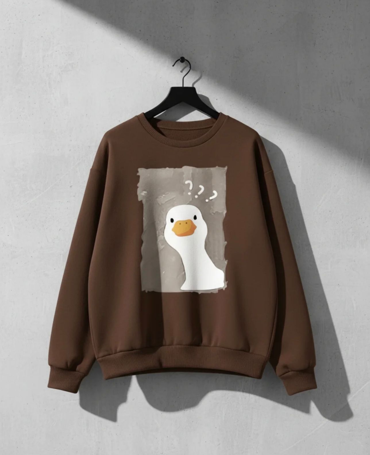 Brown crew neck sweatshirt featuring a confused cartoon duck graphic with question marks