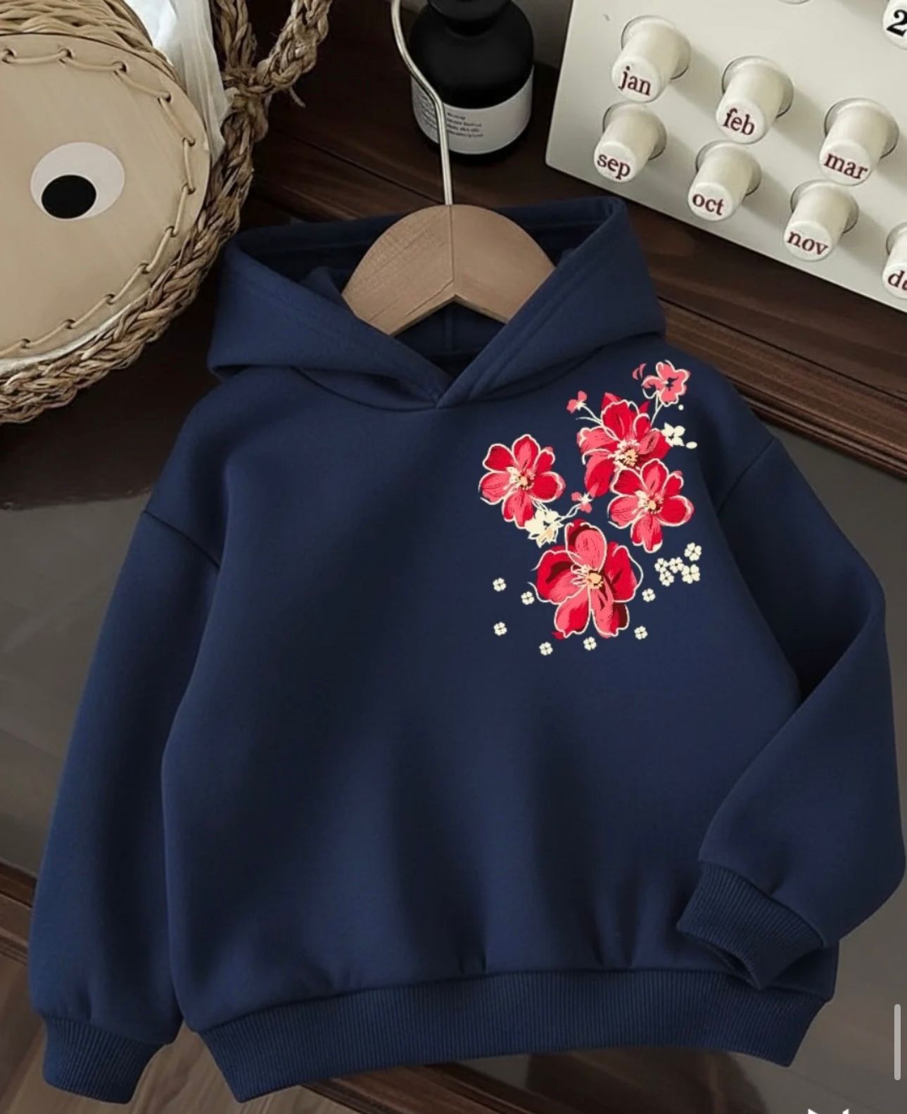 Navy blue fleece hoodie featuring a red and pink sakura blossom graphic on the chest