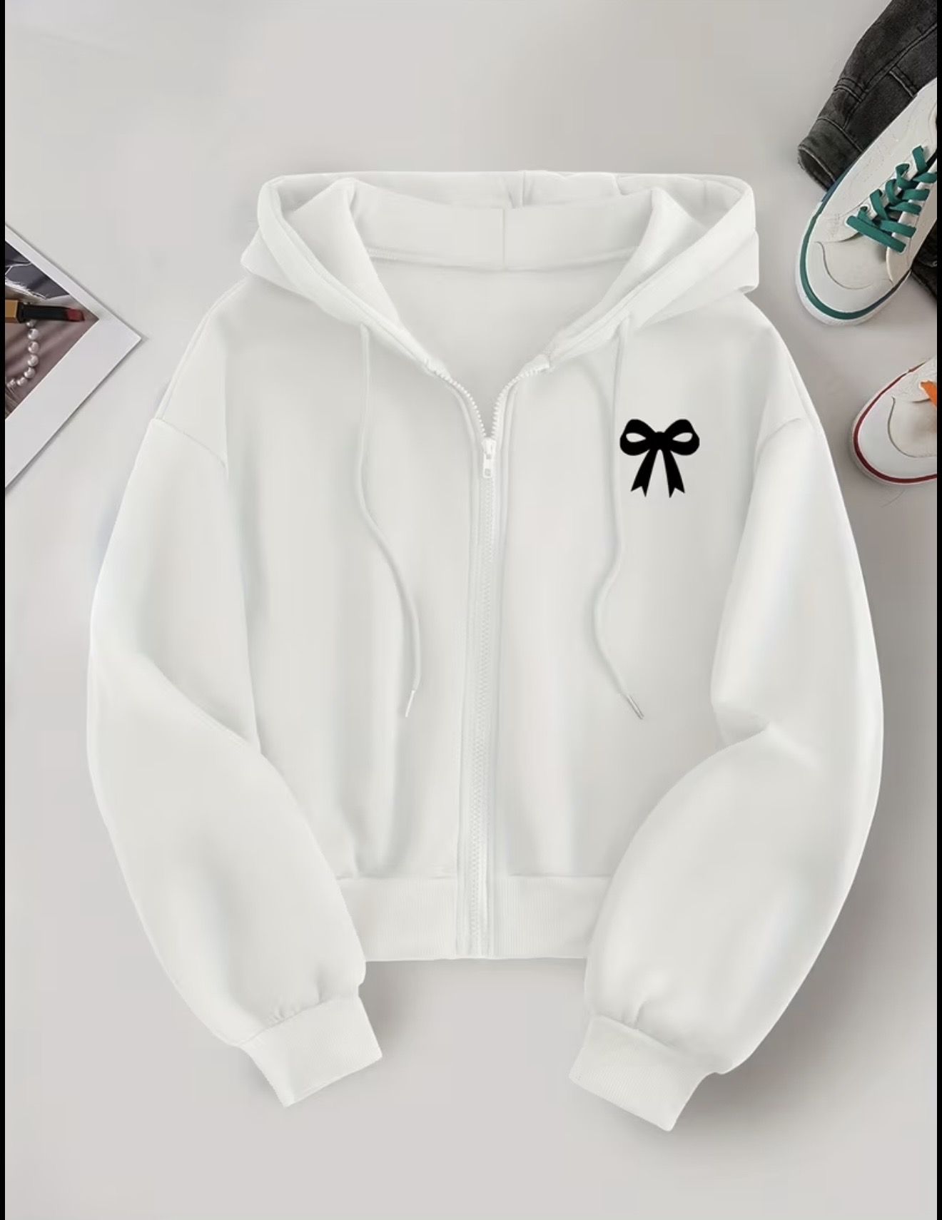 Women's zip-up hoodie featuring a small minimalist white bow print on the chest.