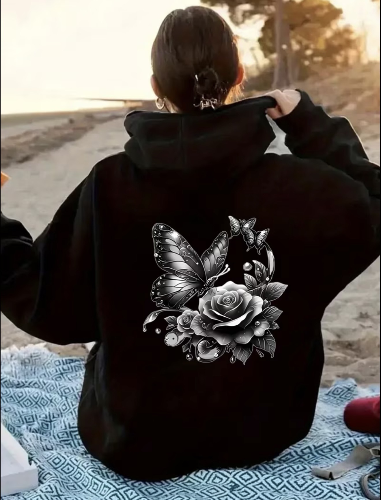 Zip-up hoodie featuring a black-and-white butterfly and rose graphic on the back with a matching smaller chest print.