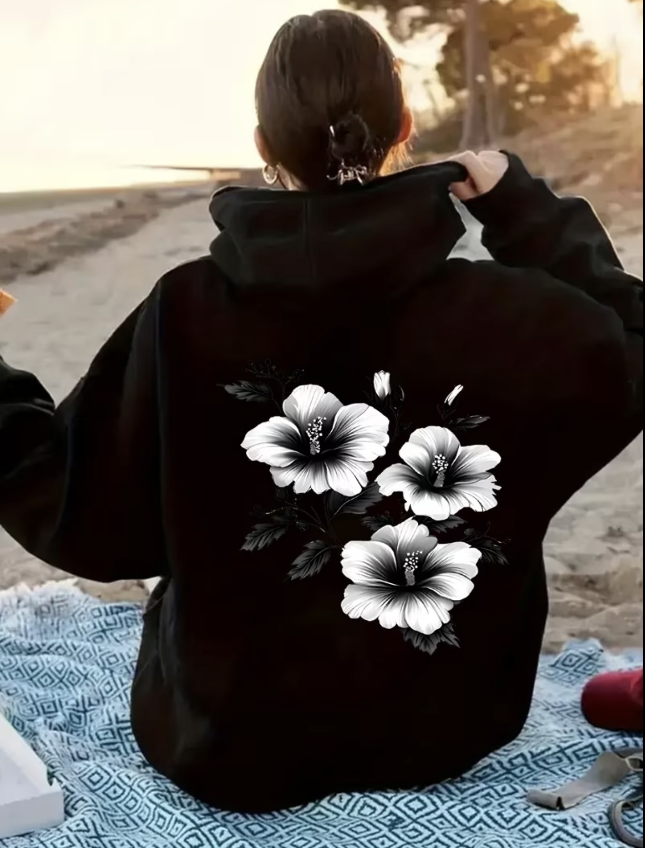 Fleece zipper hoodie with black-and-white hibiscus floral print on the left chest and a large matching flower design on the back.